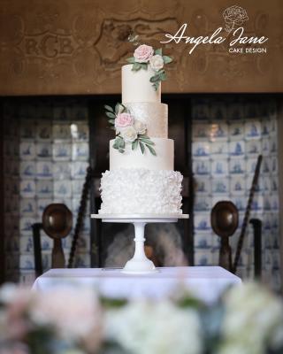 White wedding cake with wafer paper ruffles, sparkles and sugar flowers