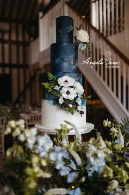 4 tier navy and white painted wedding cake with sugar flowers